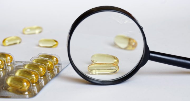 A magnifying glass pointed at omega-3 to illustrate how a third-party omega-3 verification provider, will look at your omega-3 product